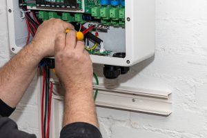 An electrician installs a new inverter